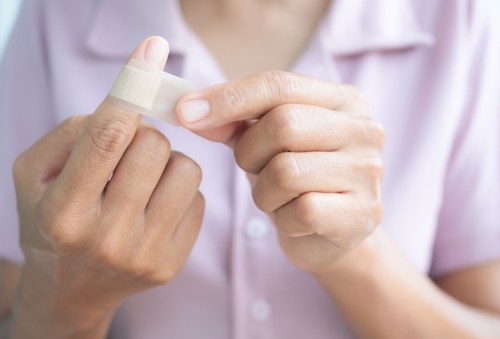 woman putting gauze on finger