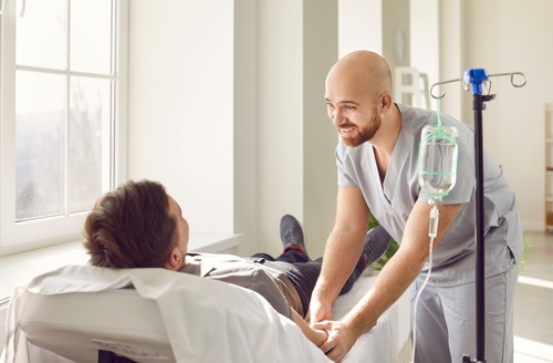 Man inserting catheter in the arm of a patient